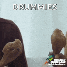 a person is holding drumsticks in their hands and the word drummies is on the bottom .