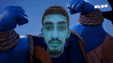 a cartoon character with a blue face and the word okeo on the bottom