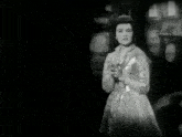 a black and white photo of a woman with the words connie francis america 's sweetheart of song below her