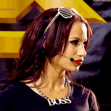 a woman wearing sunglasses and a necklace that says boss