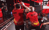 a man in a red shirt with the name zeliss on the back giving another man a high five