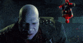 a bald man in a leather jacket with the letter t on the sleeve