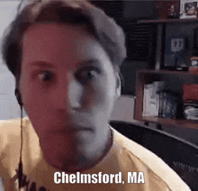 a man wearing headphones and a yellow shirt with the words chelmsford ma on the bottom