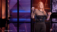 a woman singing into a microphone with the hashtag #songland on the screen