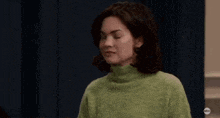 a woman is sitting in a room with a lamp and a door .