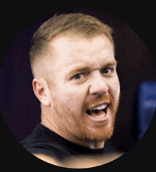 a man with a beard is smiling with his mouth wide open