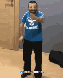 a man in a blue shirt that says hummel is dancing