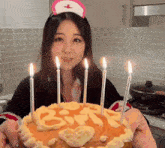 a woman in a nurse hat is holding a birthday cake