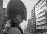 a black and white photo of a woman in front of a building with chinese writing