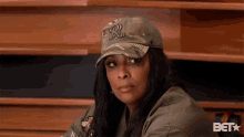 a woman wearing a hat with a letter r on it