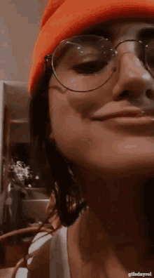 a close up of a woman wearing glasses and a beanie