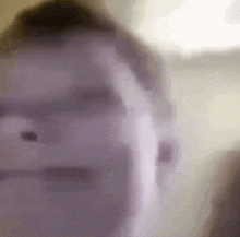 a blurry picture of a person 's face with a purple background .
