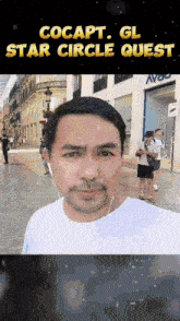 a man wearing headphones stands in front of a building with the words cocapt gl star circle quest