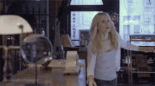 a woman is standing in front of a window that says watcher