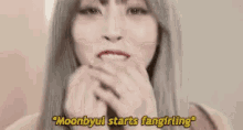 a close up of a woman 's face with the words `` moonbyul starts fangirling '' written on the bottom .