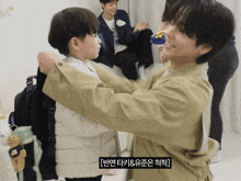 a man is hugging a little boy with korean writing on the bottom of the image