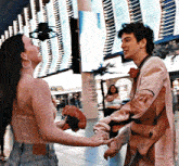 a man and a woman are holding hands in front of a building with a sign that says ' vegas ' on it