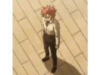 a man with red hair is standing on a wooden floor and covering his face with his hand .