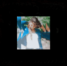 a woman in a blue denim jacket adjusts her hair