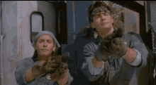 a man wearing a bandana and gloves stands next to another man wearing a bandana and gloves