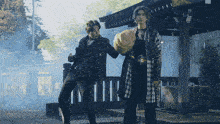 two men standing next to each other in front of a building with chinese characters on it