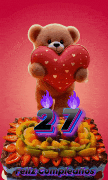 a teddy bear holding a heart on top of a birthday cake with the number 27 on it