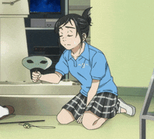 a girl in a blue shirt is kneeling down and holding an alien
