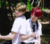 two boys with red hair are hugging each other in a park