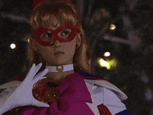 a woman wearing a red mask and white gloves is pointing