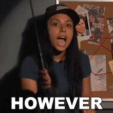 a woman holding a knife in front of a bulletin board that says however