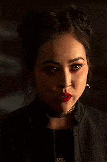 a close up of a woman 's face with red lipstick and a choker