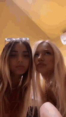 a couple of girls are standing next to each other and making funny faces .