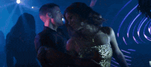 a woman in a sequined dress is dancing in a club