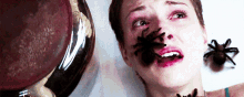 a woman with spiders on her face looks very scared