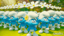 a bunch of smurfs are standing in a field with daisies