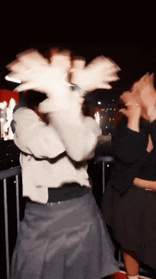 a blurry picture of a woman making a face with her hands
