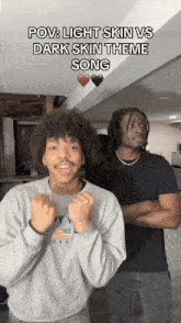 two men are standing next to each other and one of them is wearing a gray sweatshirt