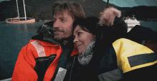 a man and a woman are hugging in front of a boat