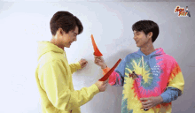 a man wearing a tie dye hoodie that says anti social social club is standing next to another man