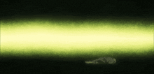 a person is laying in the dark with a yellow light behind them .