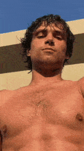 a shirtless man with wet hair on his face and chest
