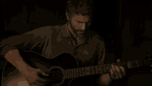 a man is playing an acoustic guitar in the dark .
