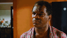 a man wearing a colorful shirt is looking at the camera