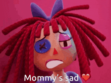 a cartoon doll with red dreadlocks and a blue button on her eye says " mommy 's sad "