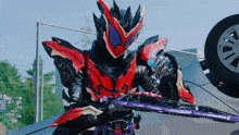 a man in a red and black armor holding a sword