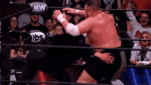 a man is wrestling another man in a wrestling ring .