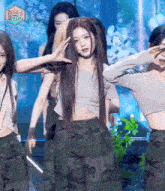 a girl in a crop top and camo pants is dancing on a stage