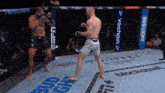 two men are fighting in a boxing ring with a bud light banner