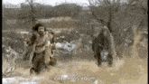 a black and white photo of a man running from a bear in a field .
