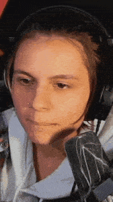 a woman wearing headphones and a nose ring is making a funny face